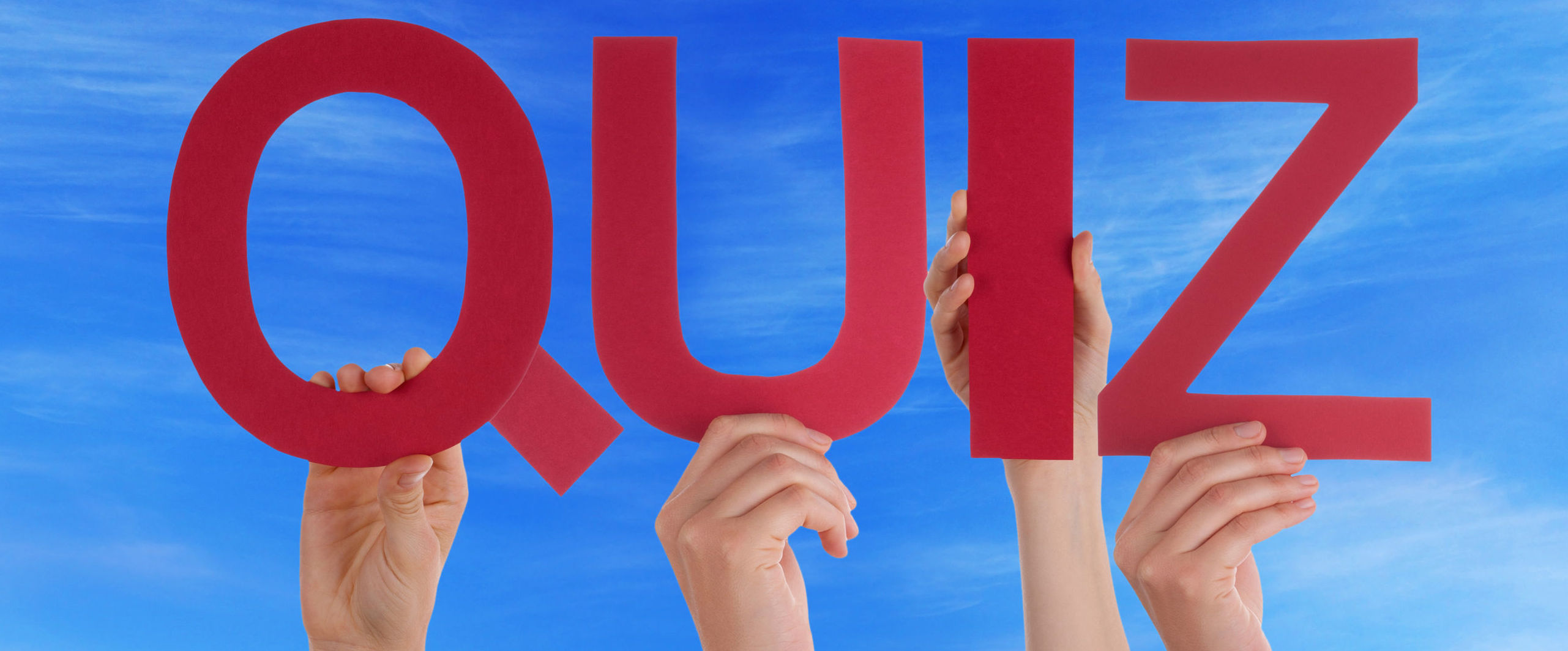 39221049 - many caucasian people and hands holding red straight letters or characters building the english word quiz on blue sky